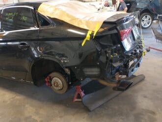 Audi RS3 undergoing collision repair, left rear quarter view