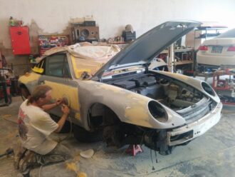Porsche auto body being sanded